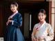 A couple of women standing next to each other in hanbok.