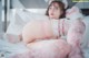 A woman laying on a bed with a teddy bear.