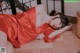 A woman in a red dress laying on the floor.