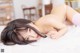 A woman laying on top of a white bed.