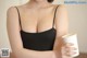 A woman in a black bra holding a cup of coffee.