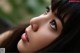 A close up of a woman's face with long black hair.