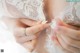 A close up of a woman's hands with a wedding ring.