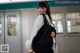 A woman with a backpack standing in front of a train.